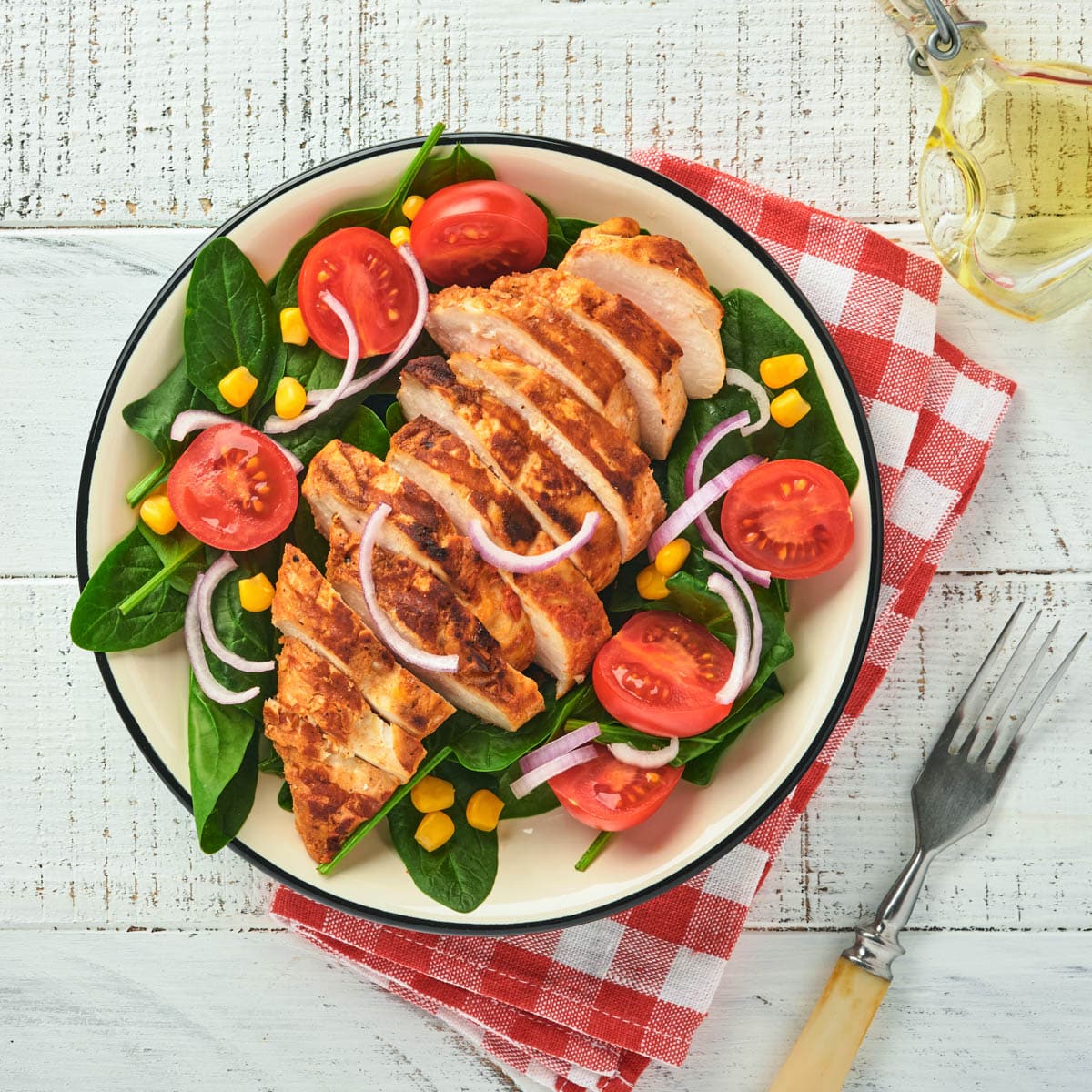 Salad with fresh spinach, tomatoes ad grilled chicken.