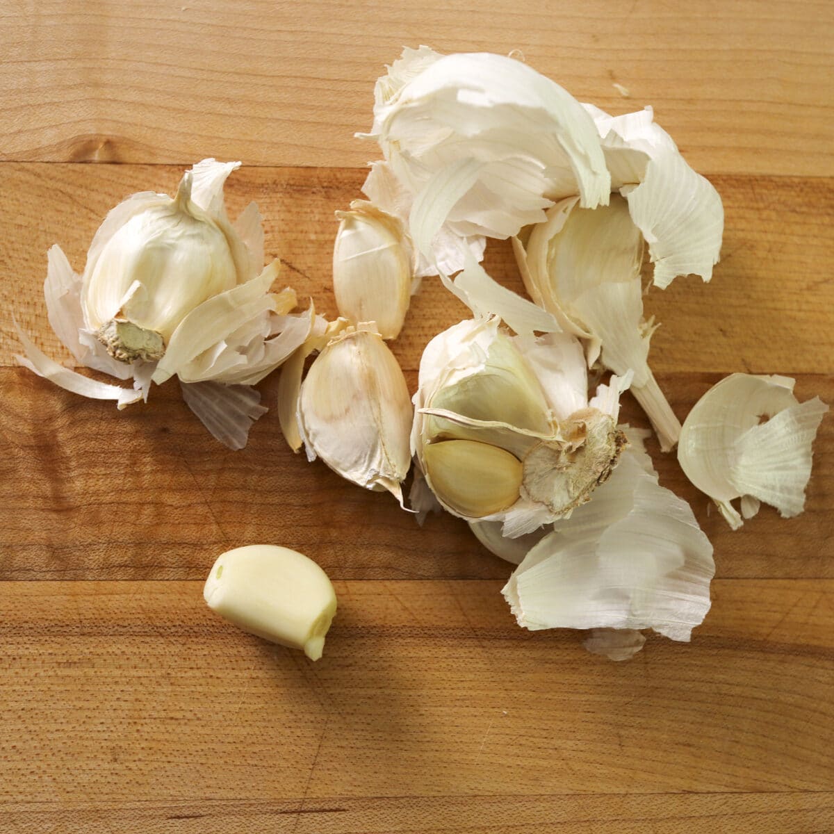 peeled garlic on a cutting board