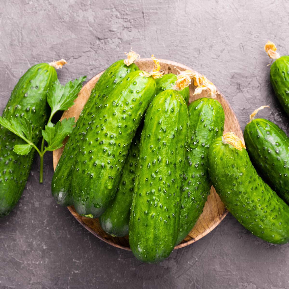 A Harvest of fresh cucumbers on a wooden platter.