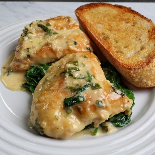 chicken florentine on a plate with toasted bread