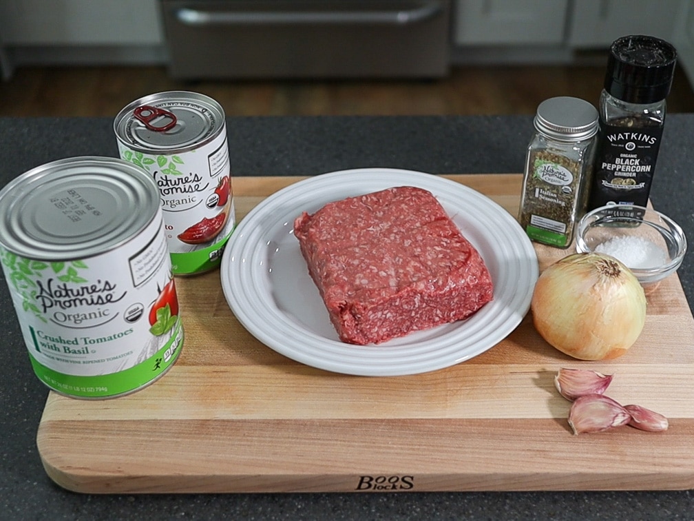 ingredients on a cutting board for a spaghetti meat sauce
