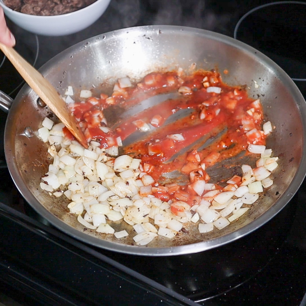 deglazing the pan with tomato sauce
