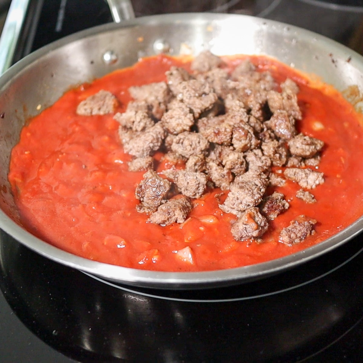 adding ground beef cooked back to the pan