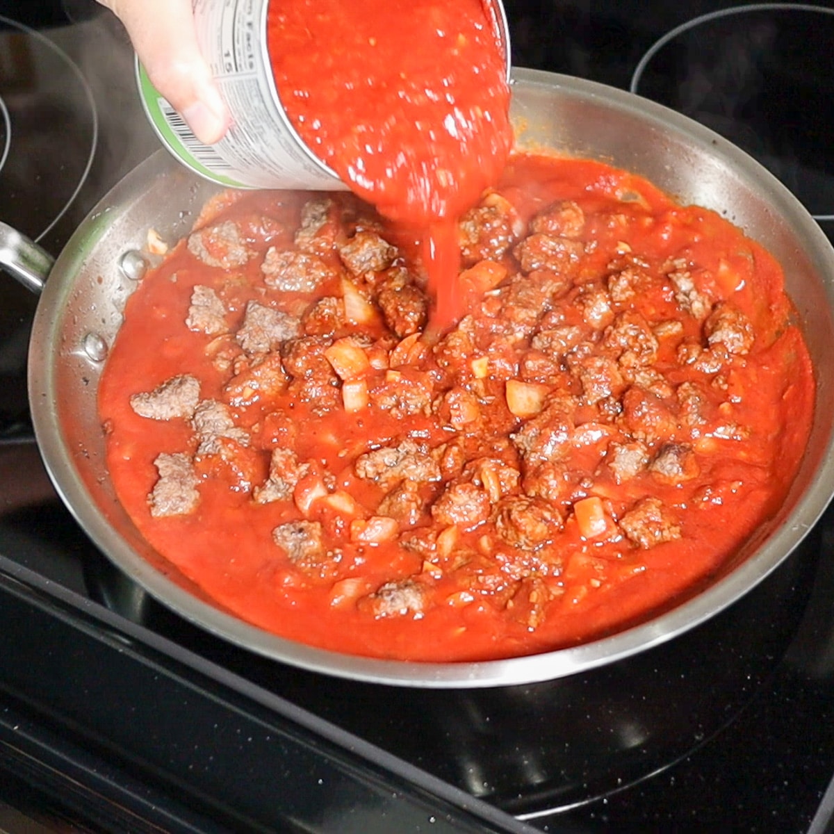 adding crushed tomatoes