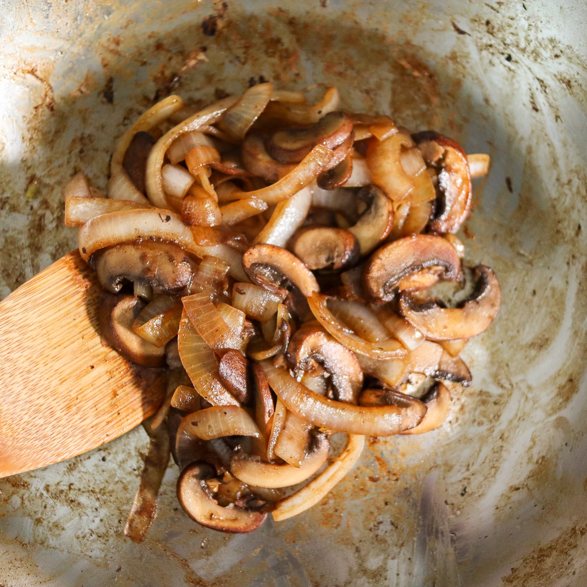 onions and mushrooms sauted in a pan