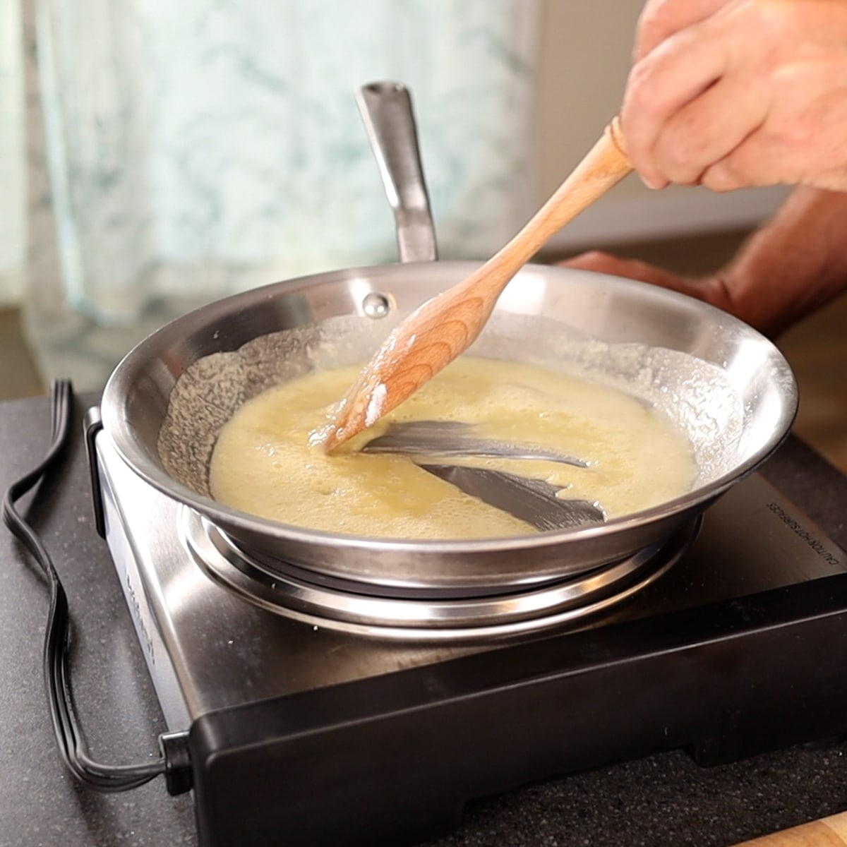 making a béchamel sauce in a frying pan