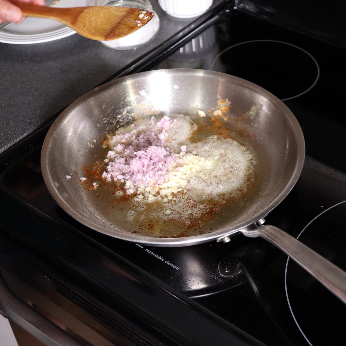 mixing the shallots and garlic in the pan