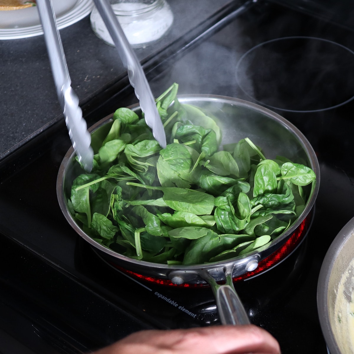 adding the spinach to the heated skillet