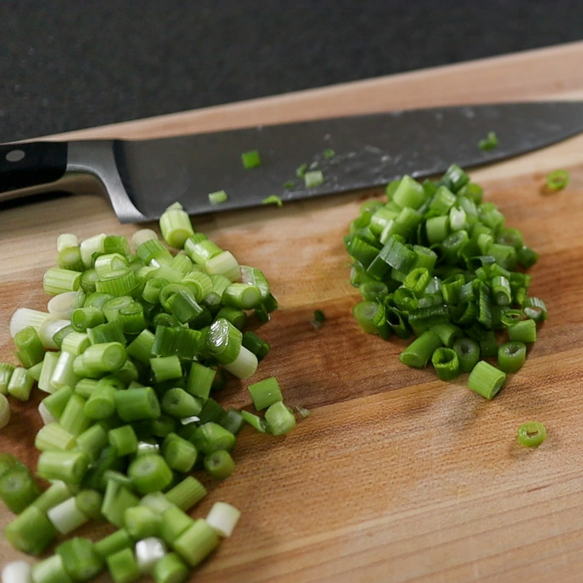 Cut up green onions on a cutting board.